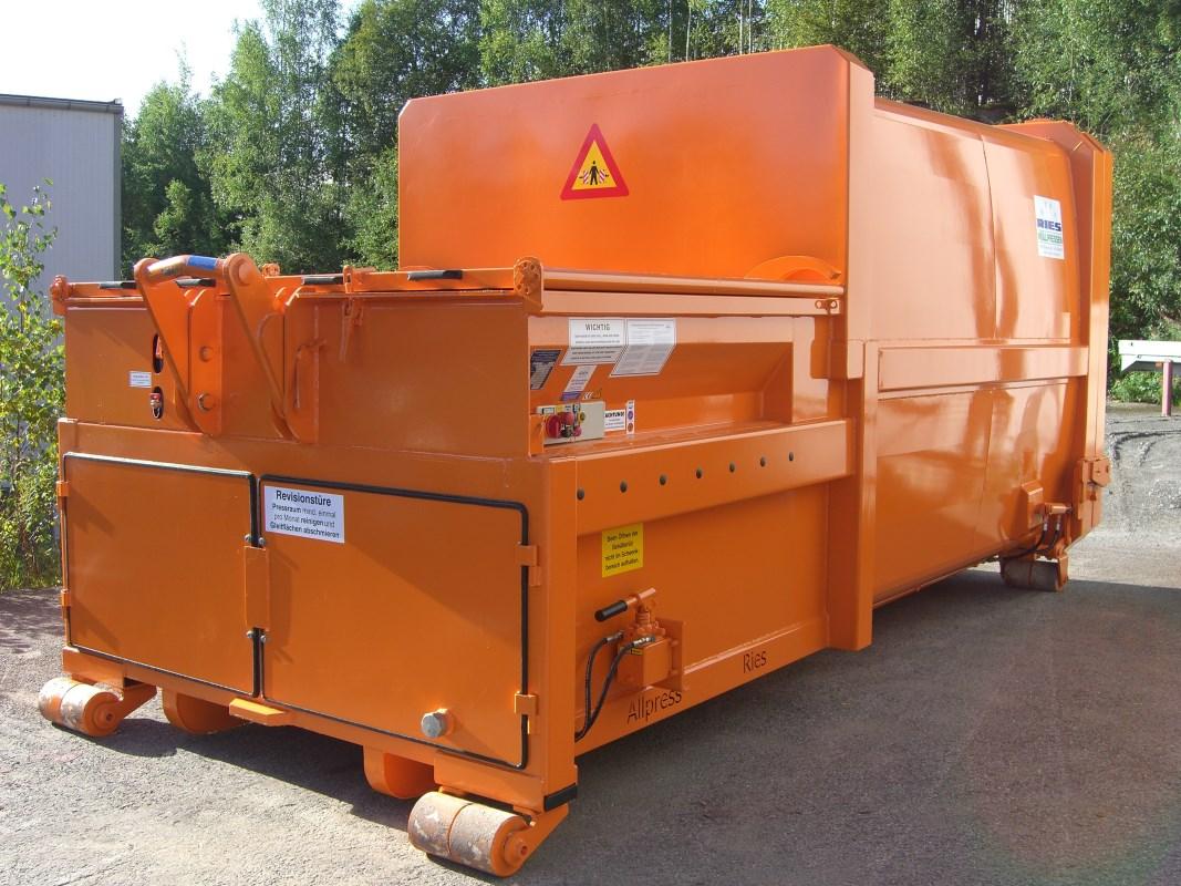 A big orange industrial garbage compressor